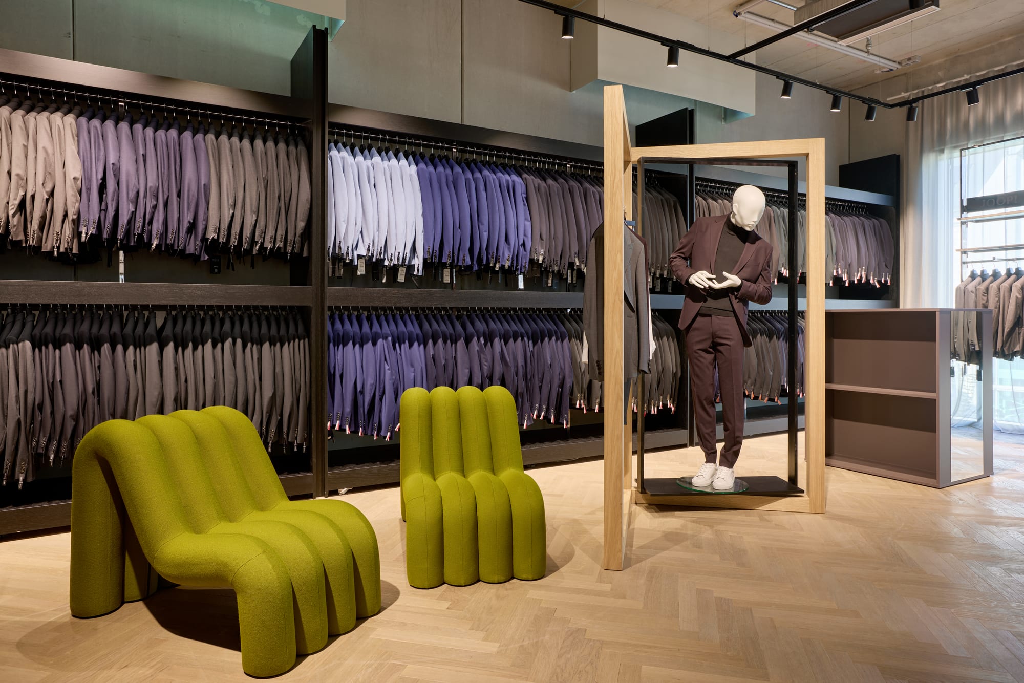 Kleider Bauer Linz — Kleiderwand mit Loungesesseln